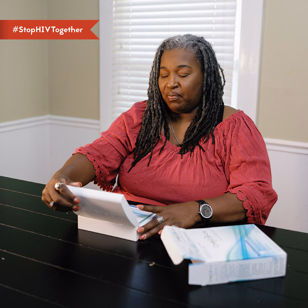 Self-Testing – Orisha An image of a woman opening an HIV self-test kit.