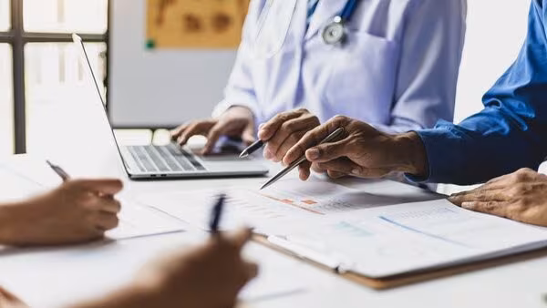People working at a desk Multiple people working at a desk