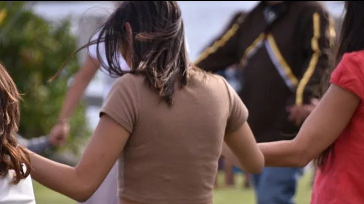 AI/AN Community gathering with members holding hands. Photo of AI/AN community holding hands in a circle.