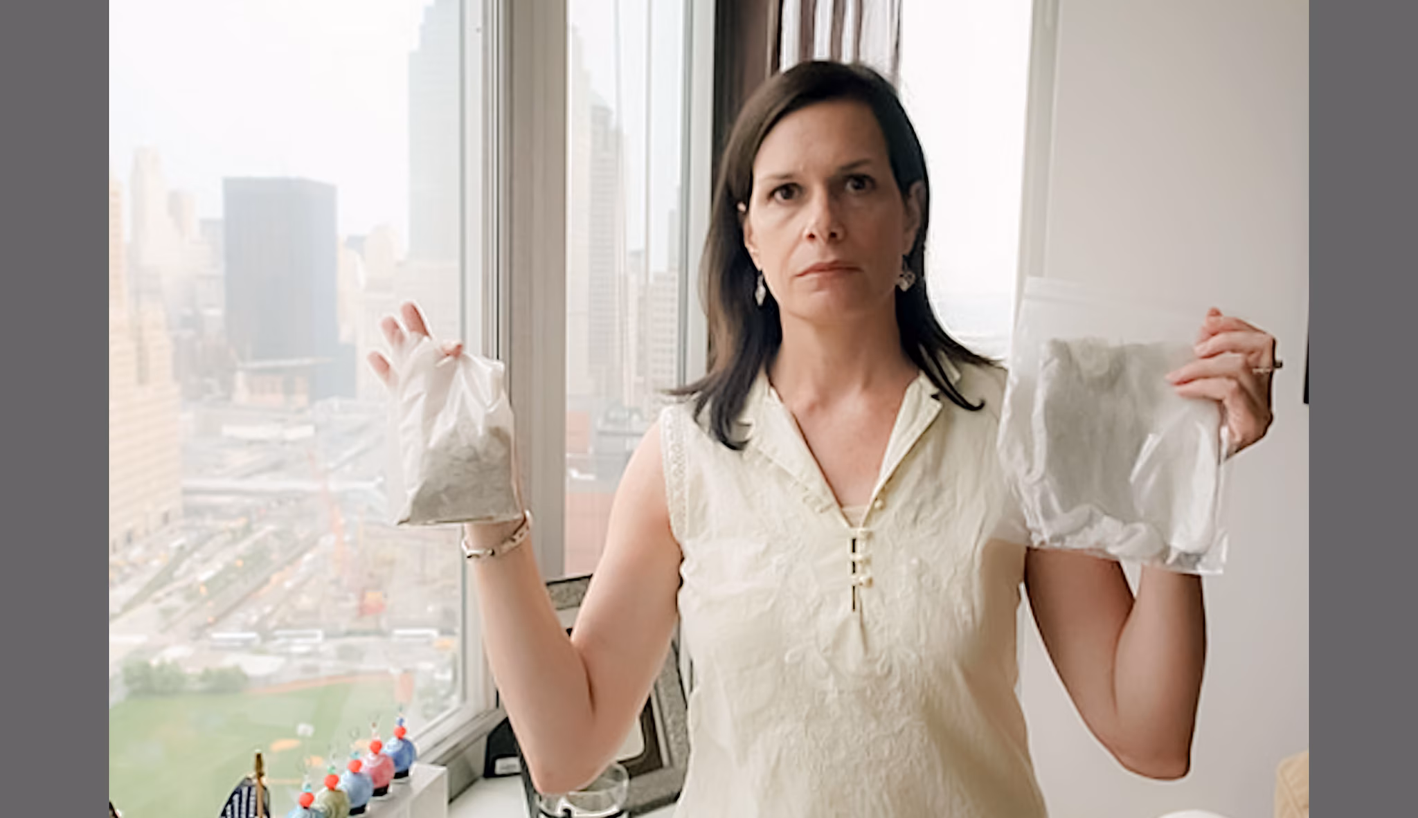 Woman holding a baggie of dust from her apartment and the cheesecloth she used to filter her air conditioner.