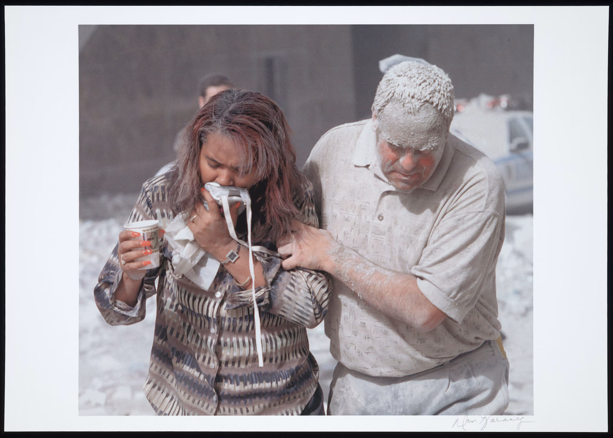 Two people covered in dust evacuate from Ground Zero.