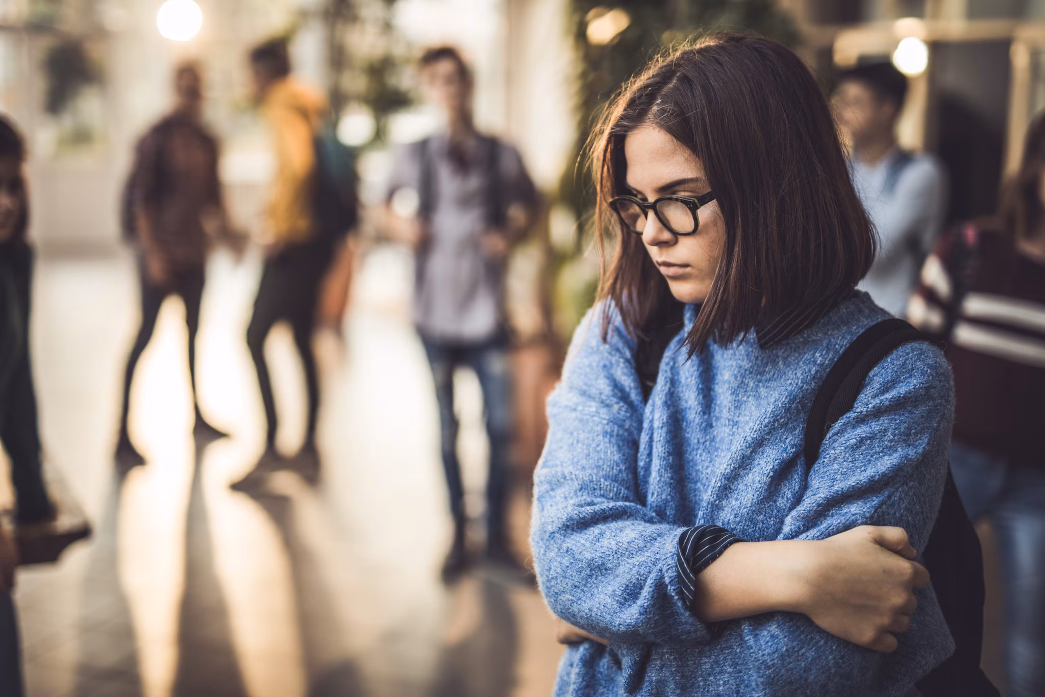 Sad-high-school-student Sad female high school student standing alone in the hallway